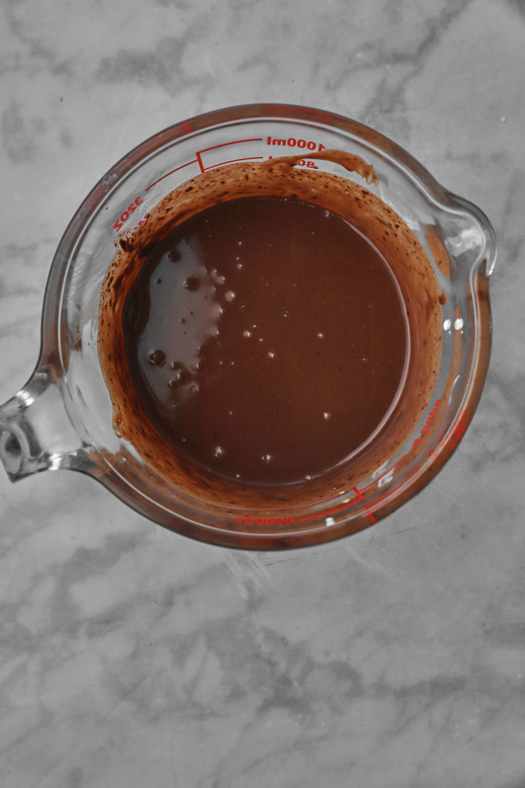 stirred melted chocolate and cream in a measuring cup.