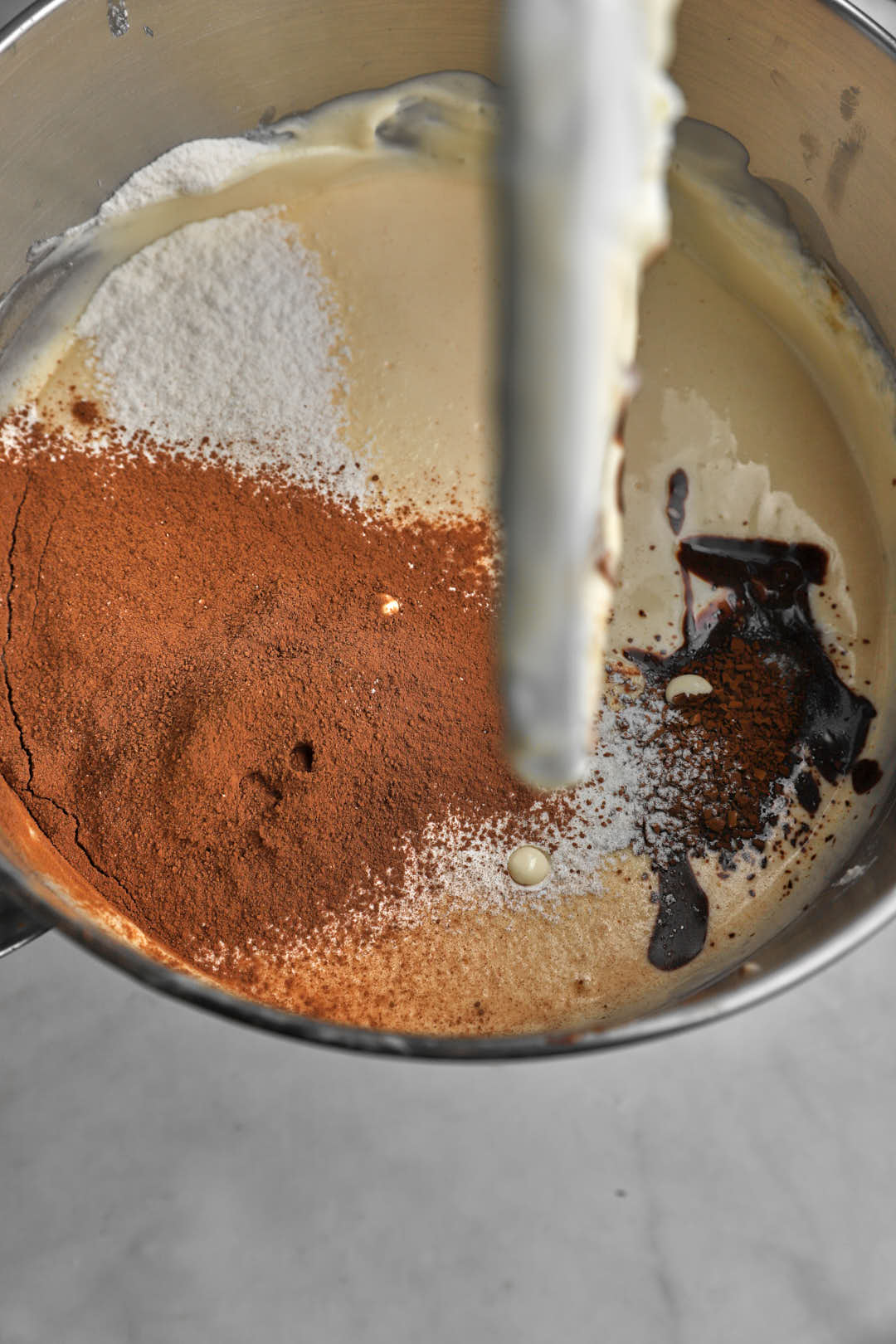 Cocoa powder and melted chocolate added to the cheesecake batter in a stand mixer.
