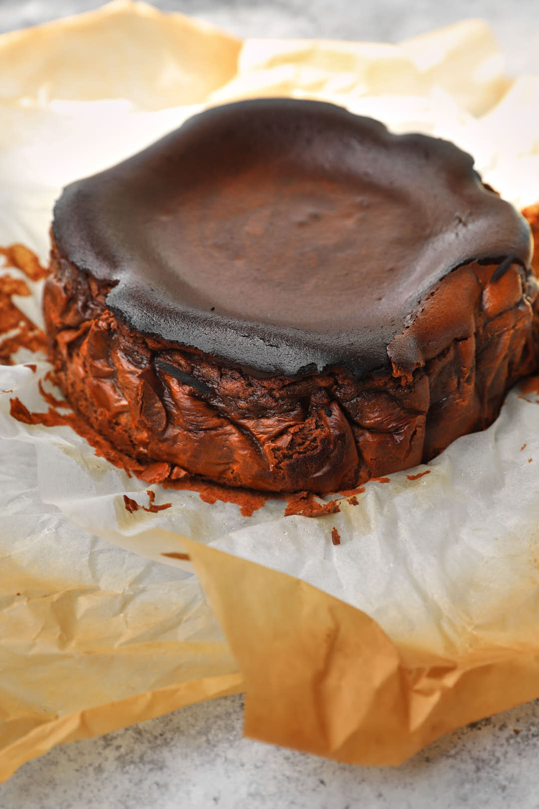 Chocolate basque cheesecake on parchment paper.