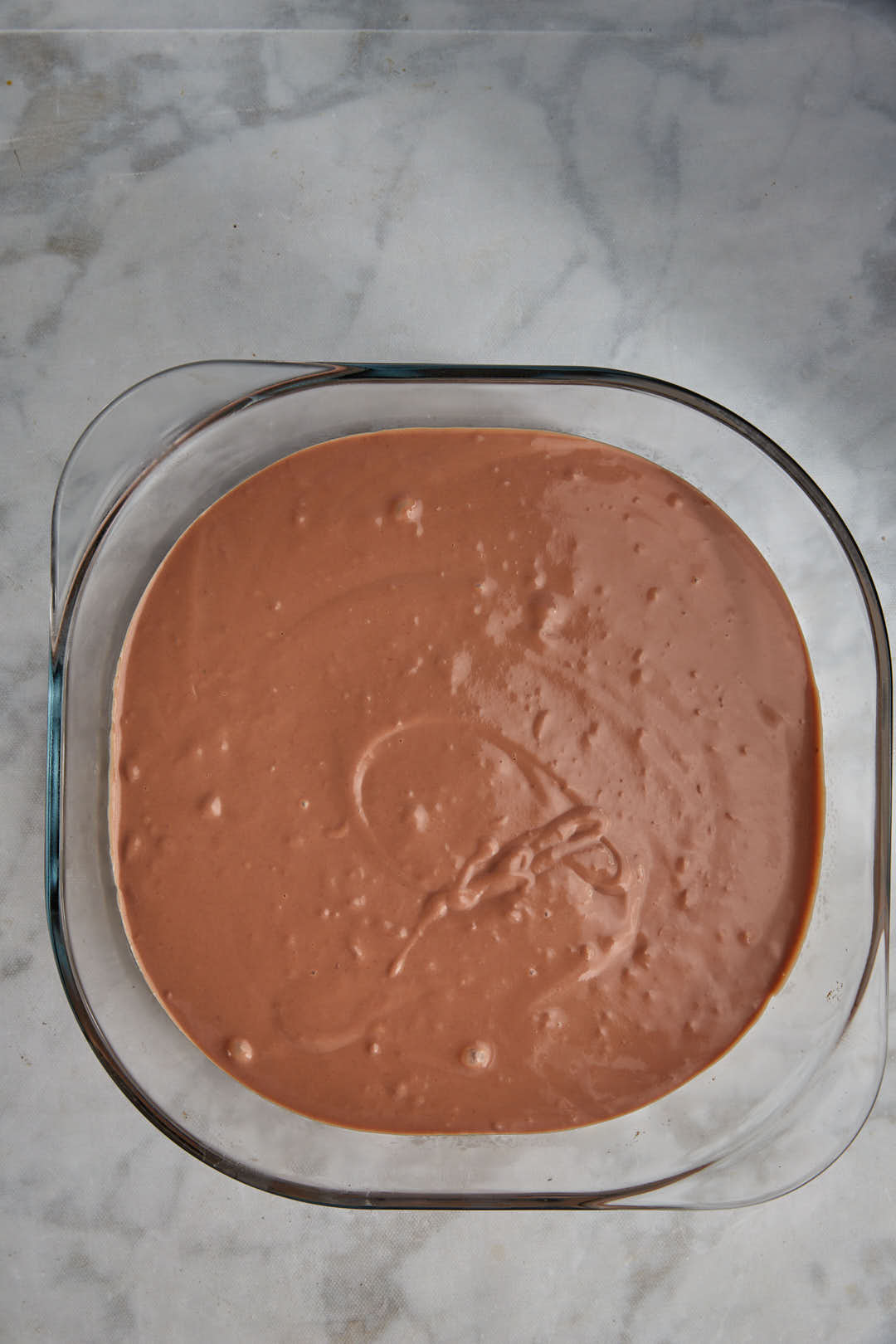 chocolate pudding spread out in a pyrex pan.