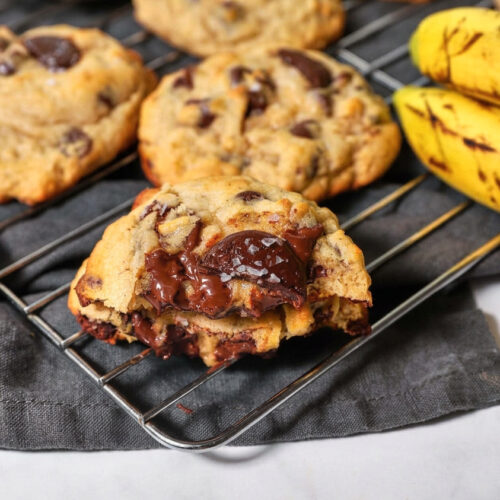 chocolate chip banana bread cookies on a wire cooling rack with bananas .