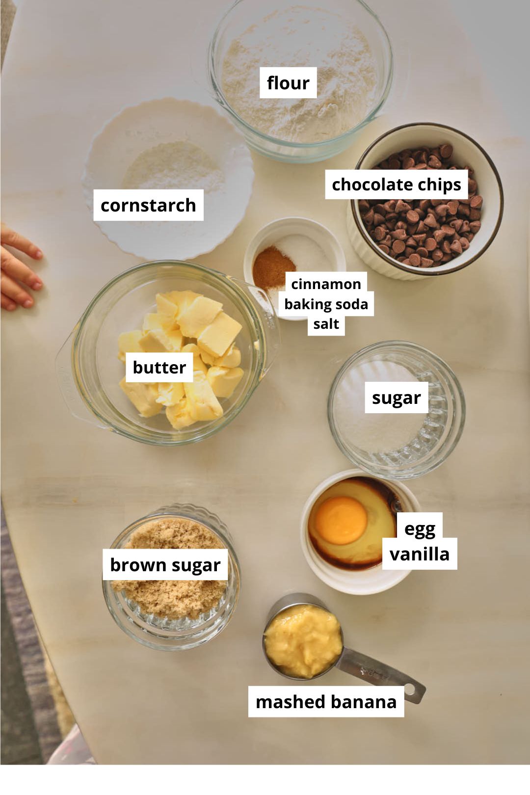 ingredients needed to make banana bread cookies on a white marble table.