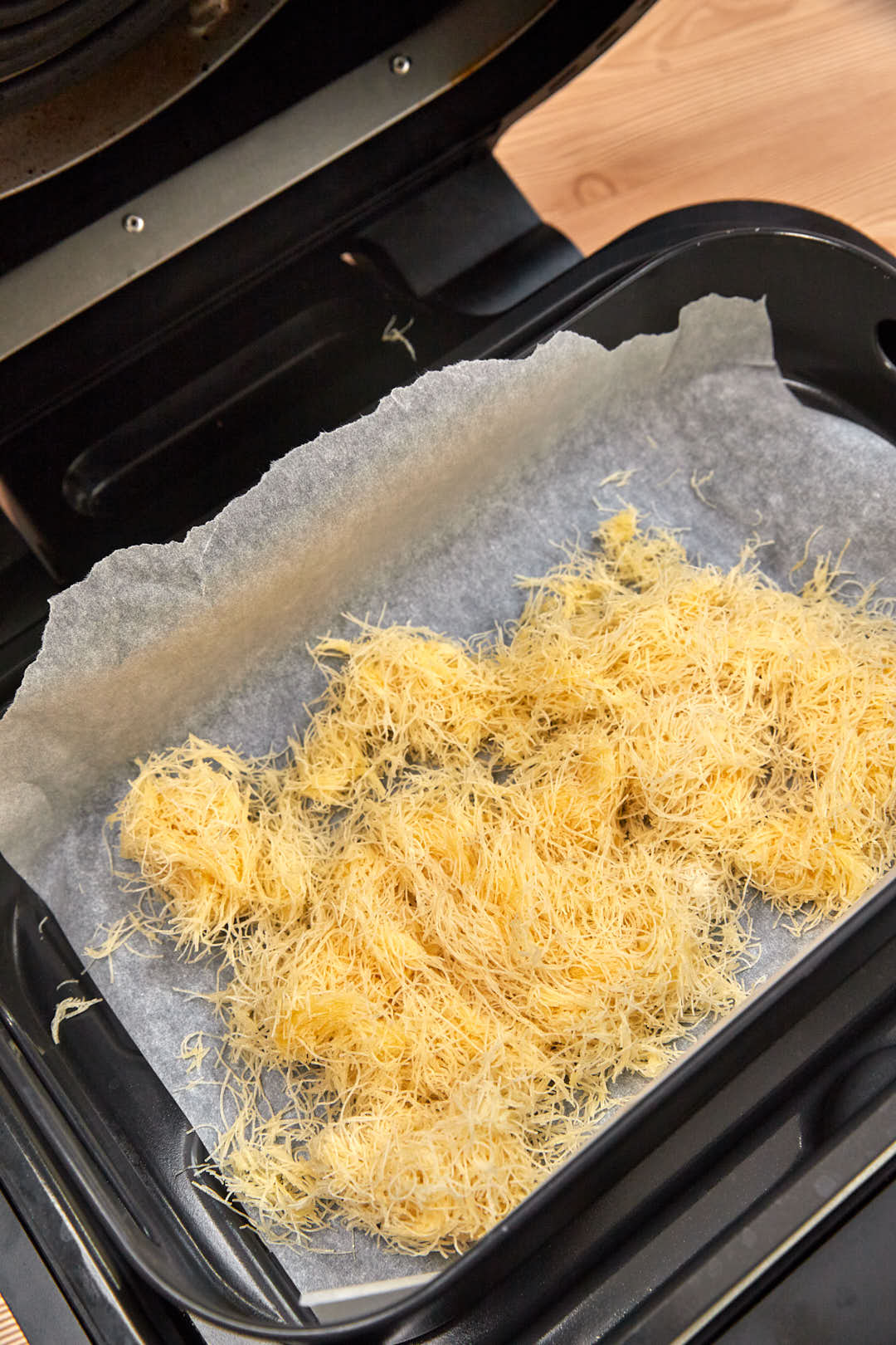 kunafa before air frying in air fryer basket.