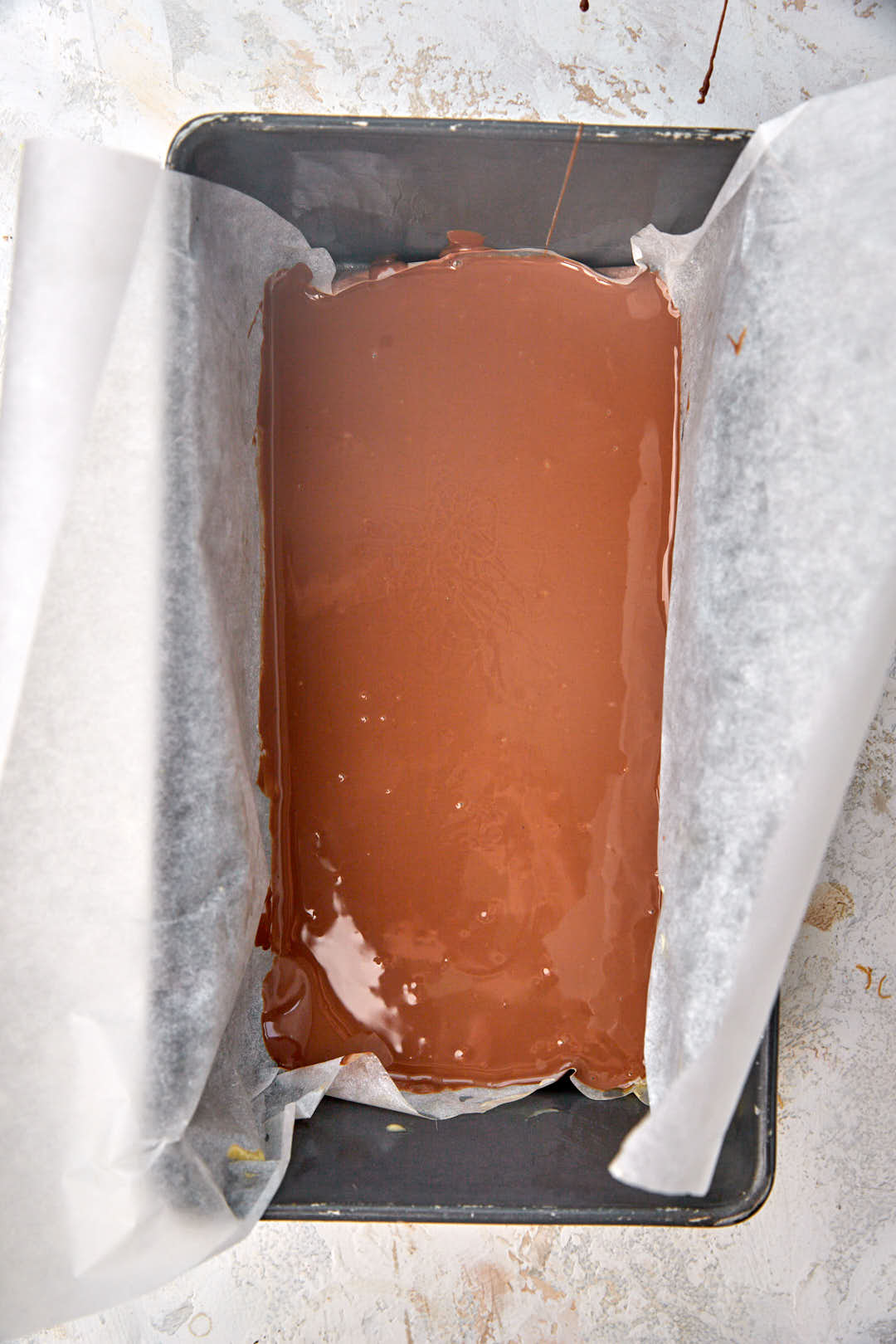 first layer of melted chocolate in loaf pan.