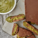 chocolate kunafa with pistachio spread in a bowl on the side on a white background.