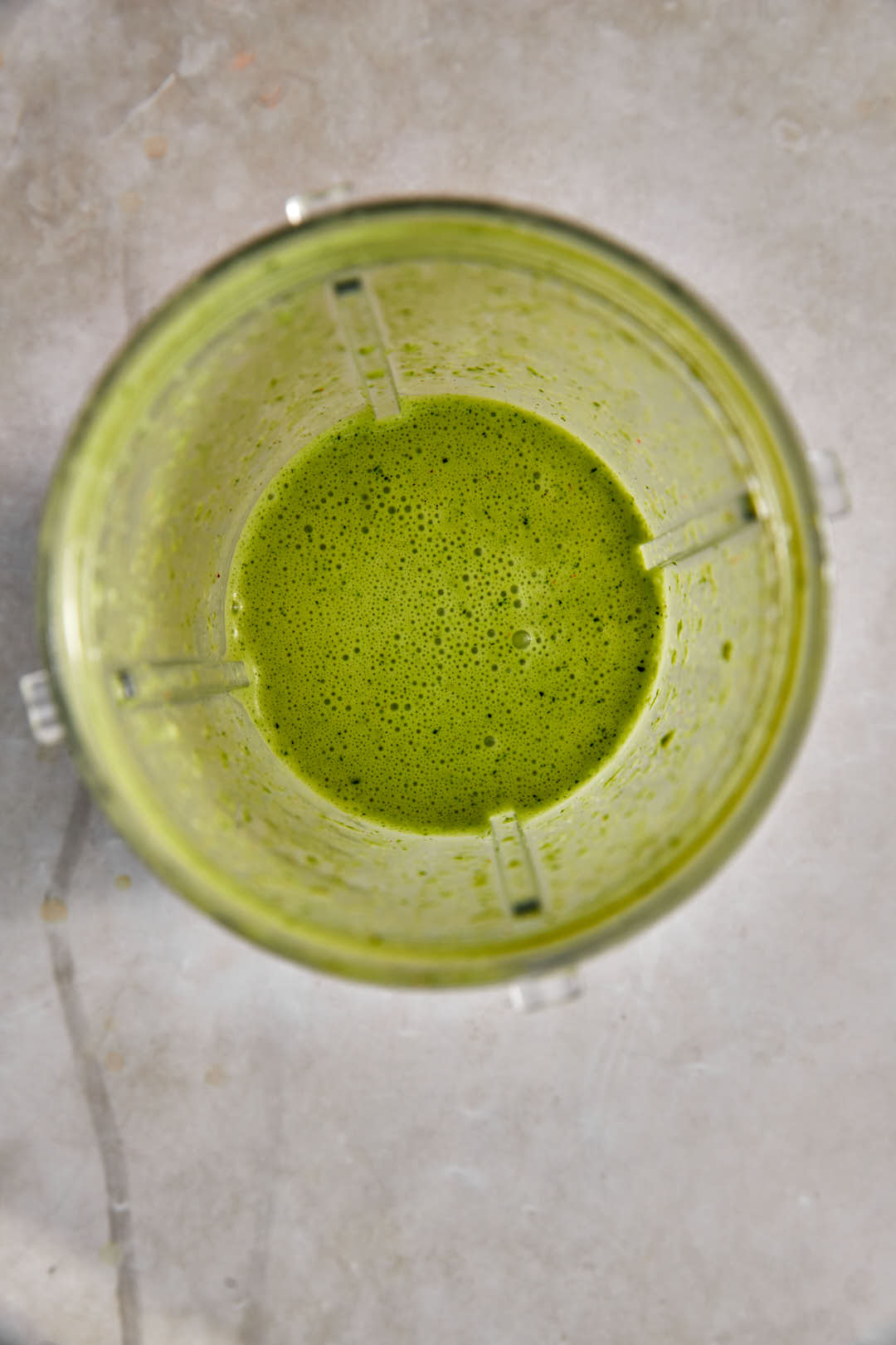 creamy green salad dressing in bowl of small plastic blender.