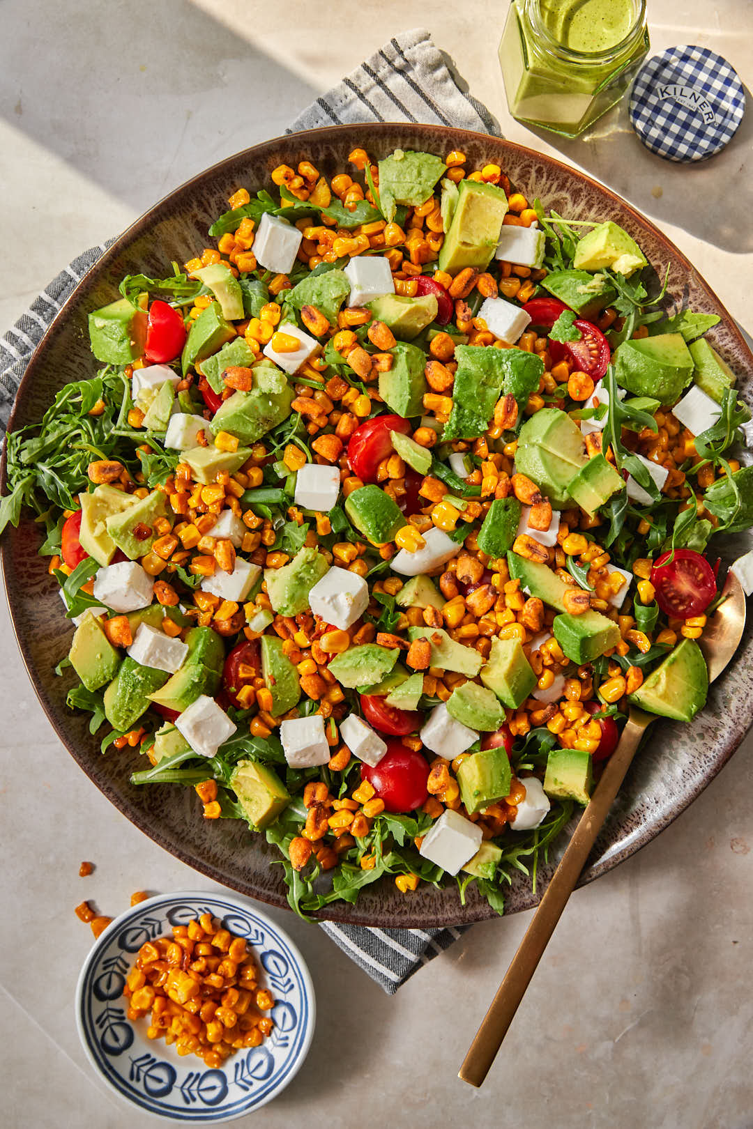 assembled corn and arugula salad on large serving dish.