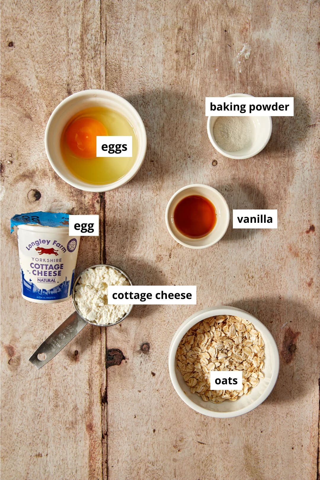 ingredients needed to make cottage cheese pancakes on a wood background.