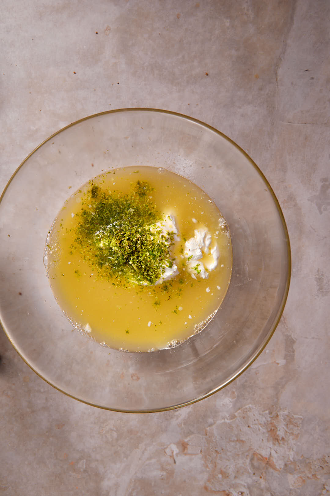 lime juice, zest, condensed milk and sour cream in glass bowl.
