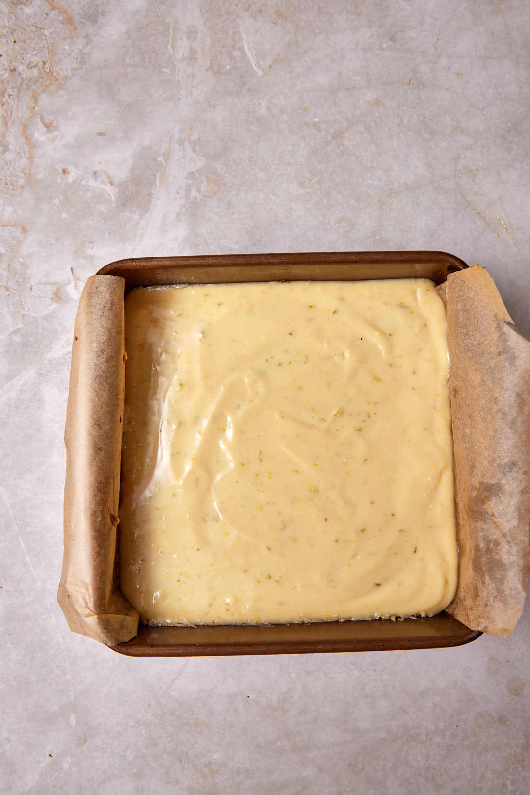 key lime pie bars in a square baking dish after baking.