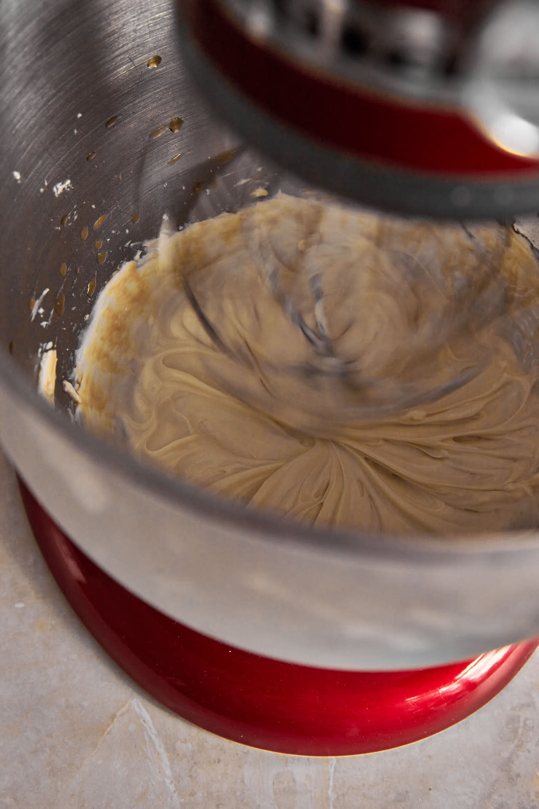 cream cheese and powdered sugar in the bowl of a kitchenaid mixer.