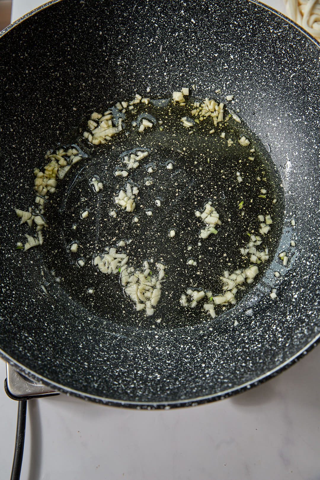 hot olive oil in a skillet with crushed garlic.