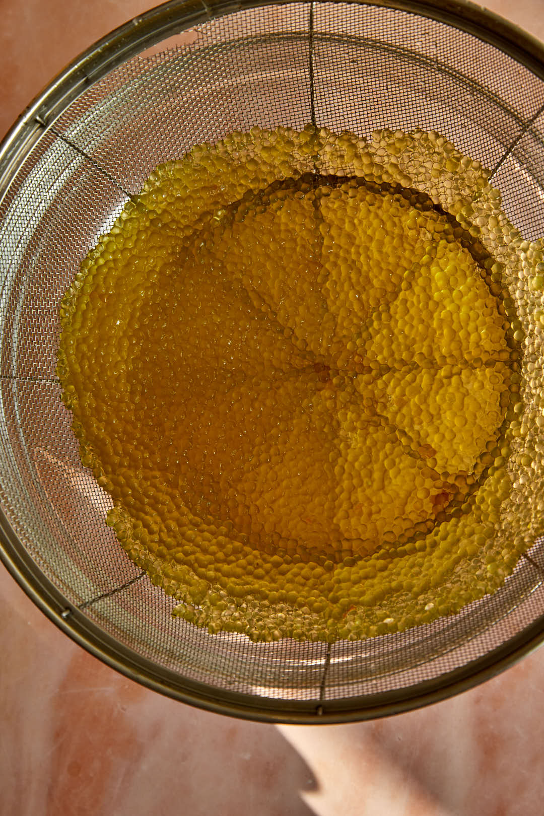 strained sago in a sieve over a glass bowl.