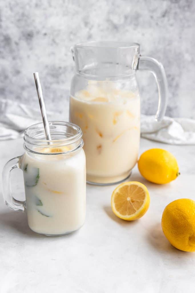 creamy lemonade in mason glass with pitcher in the background