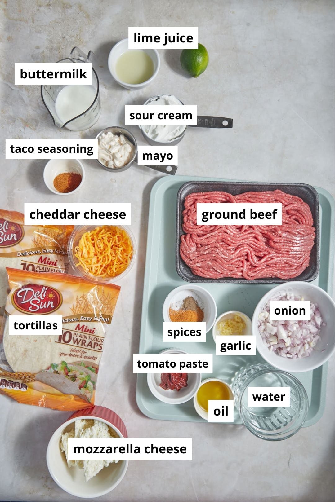 ingredients needed to make crispy beef tacos on a white background.