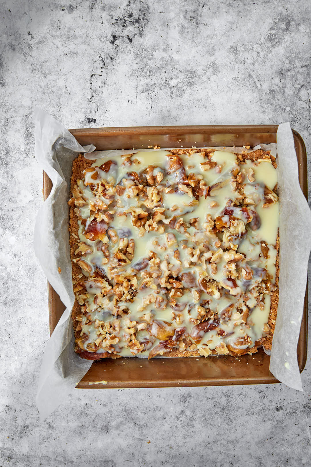 condensed milk topped date bars before baking in pan.