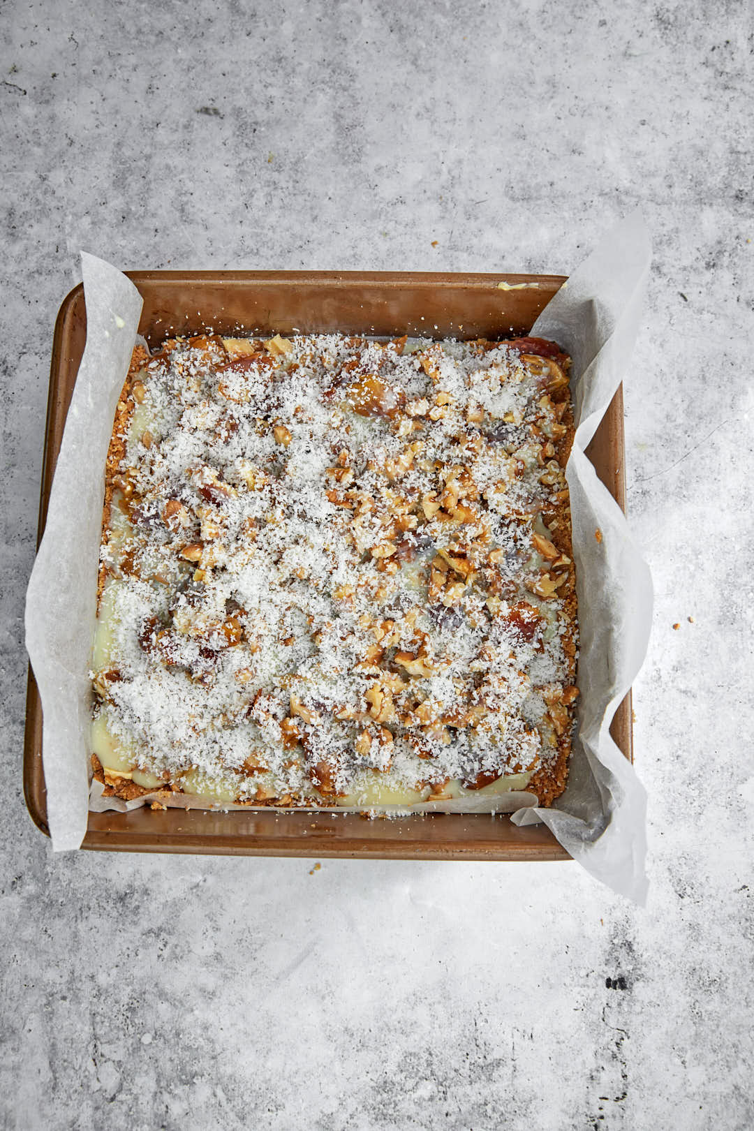 coconut topped date bars before baking in pan.