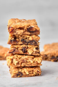 Zoomed in photo of 5 date and walnut blondies stacked on top of each other.
