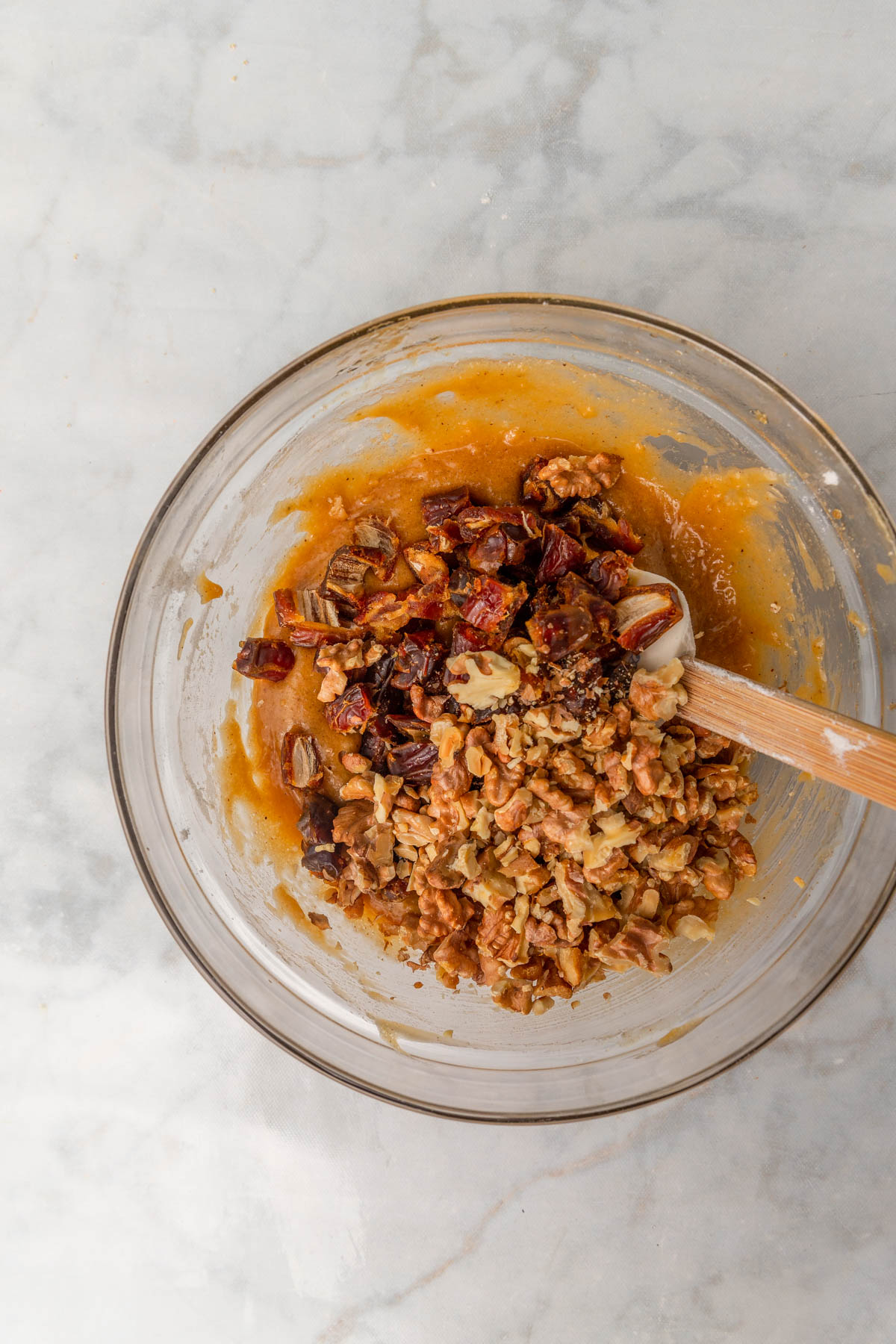 chopped dates and walnuts added to blondie batter in a glass bowl.