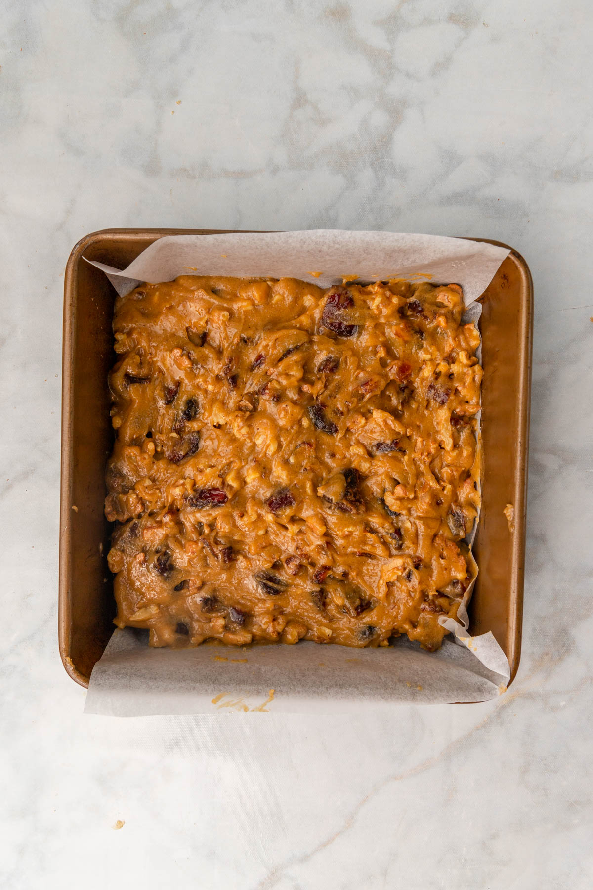 date blondie batter spread into a square pan.