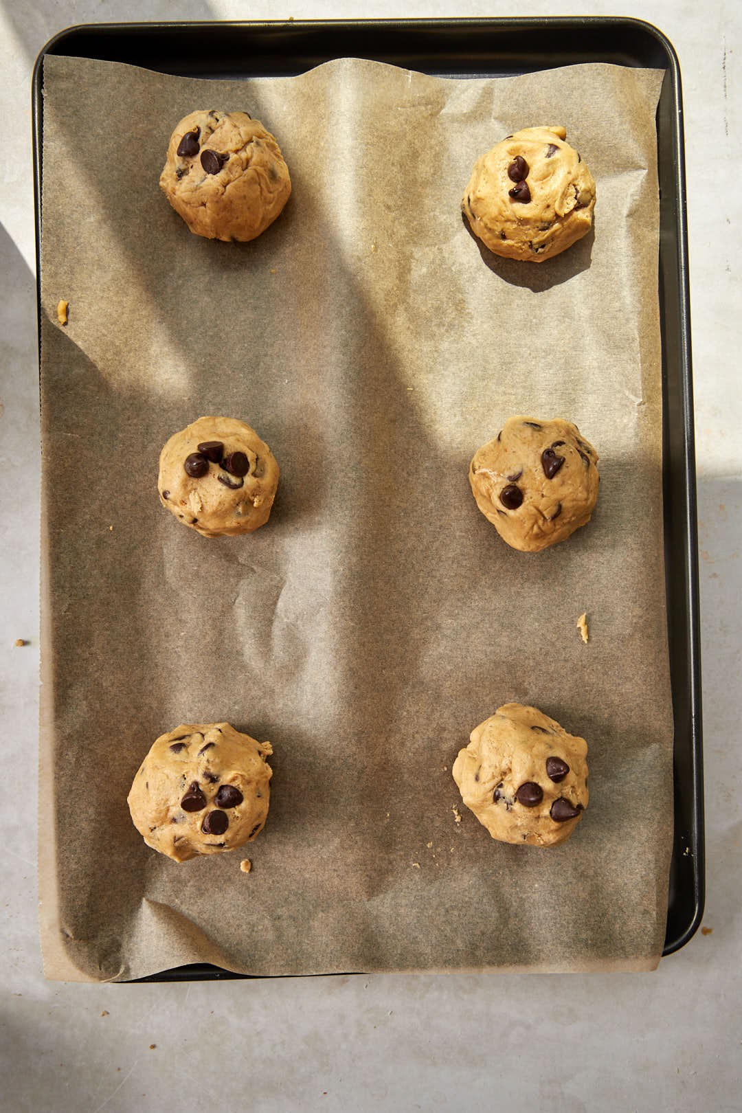 cookie dough balls on a baking sheet before baking.