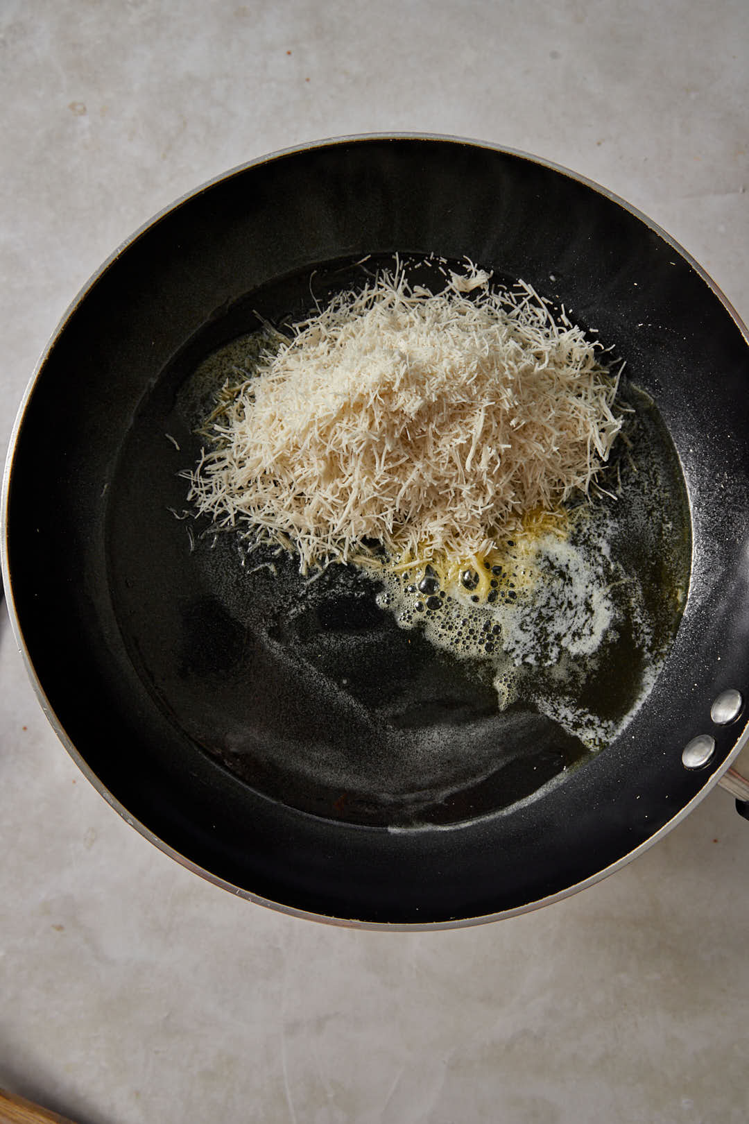 shredded kunafa dough in a large skillet with melted butter.