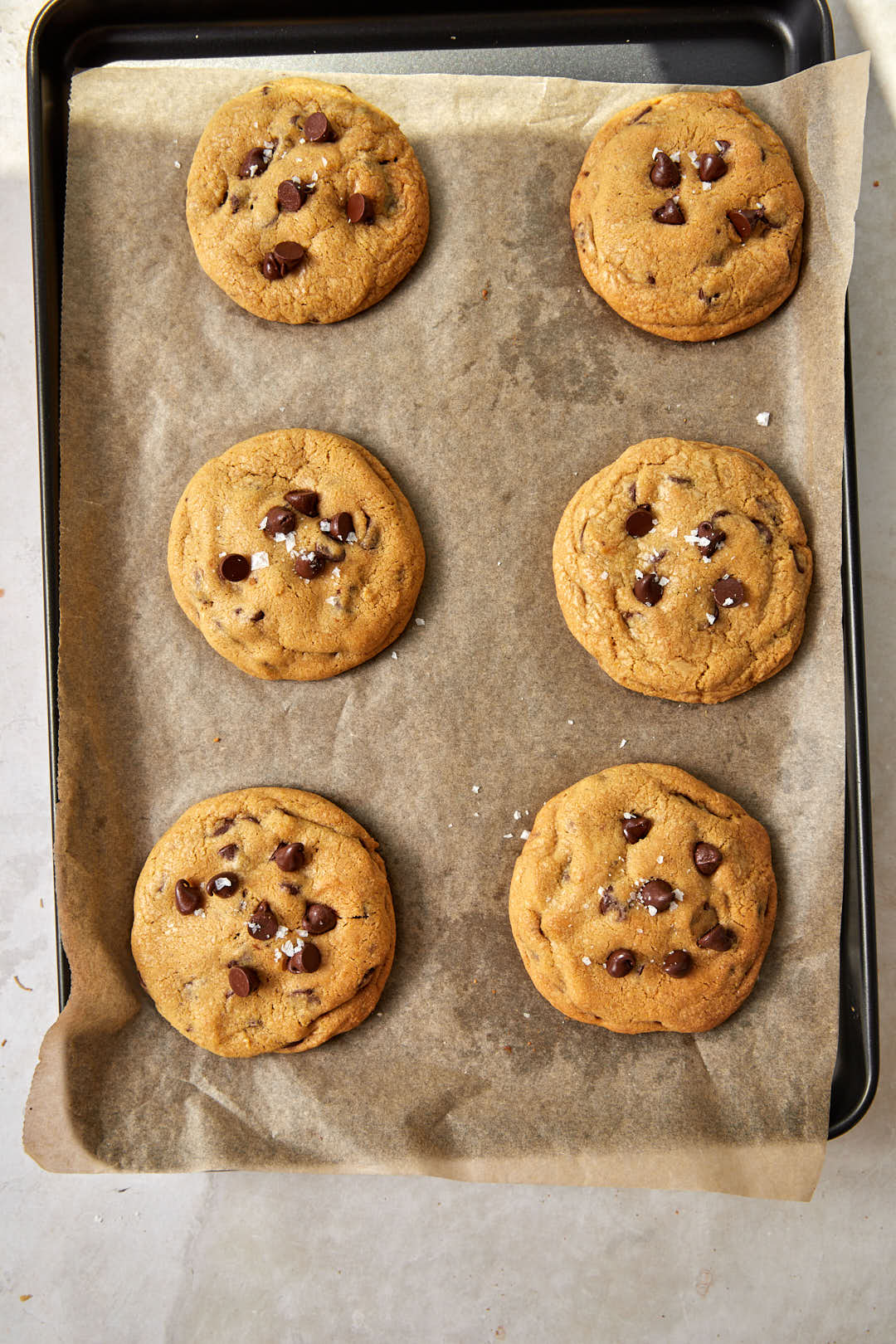 golden brown baked cookies on a parchment paper lined baking sheet.