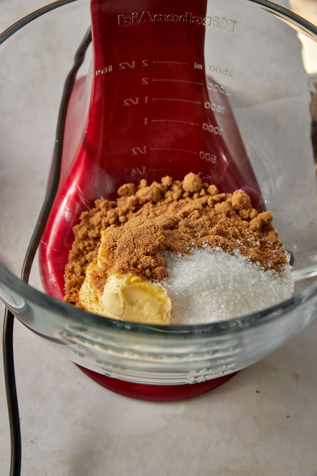 light brown sugar, granulated sugar and softened butter in the glass bowl of a kitchen aid.