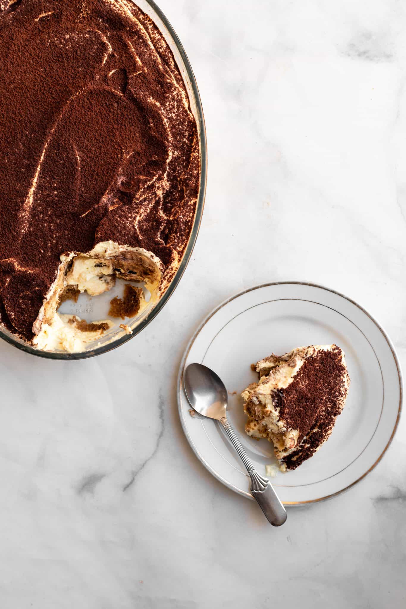 non alcoholic eggless tiramisu in a pyrex dish, with a scoop on a plate.