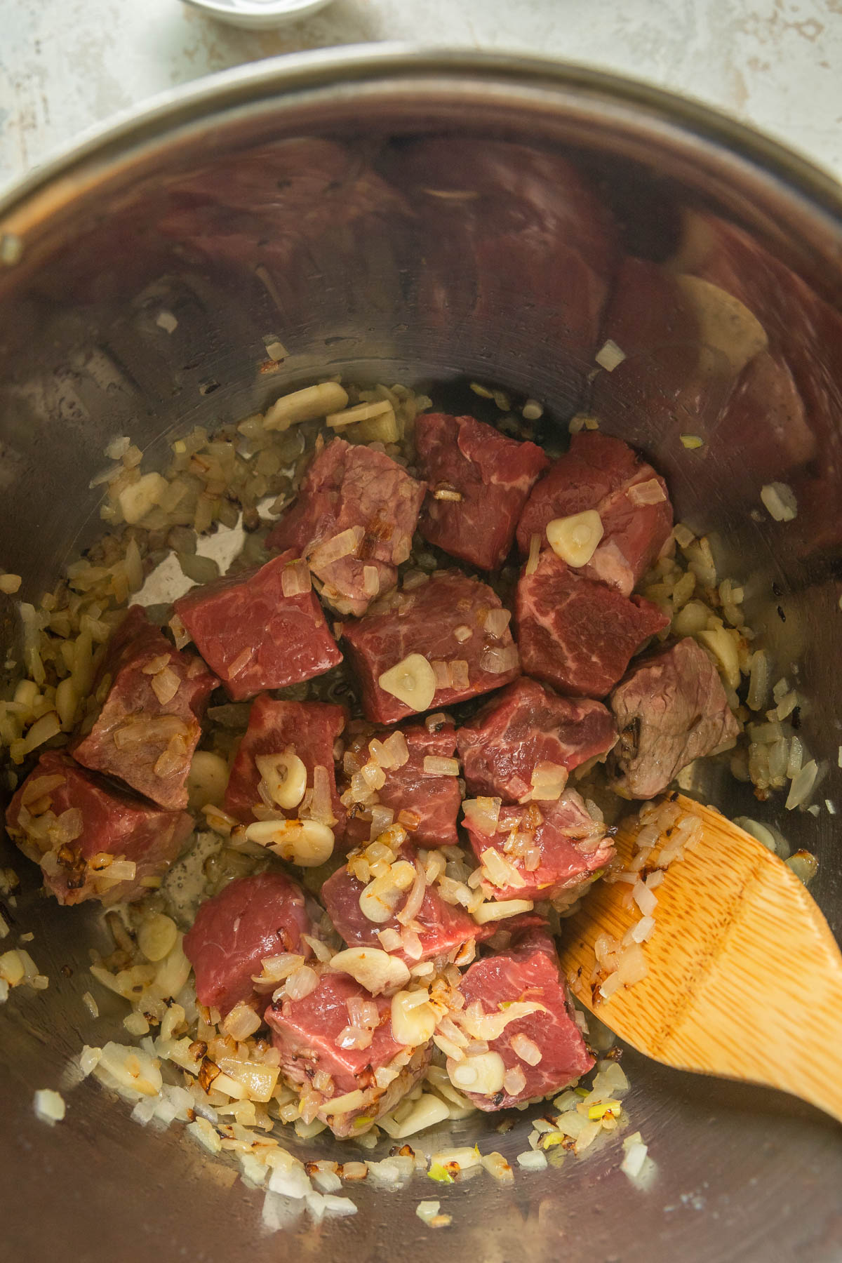 Beef cubes before cooking in a pan.