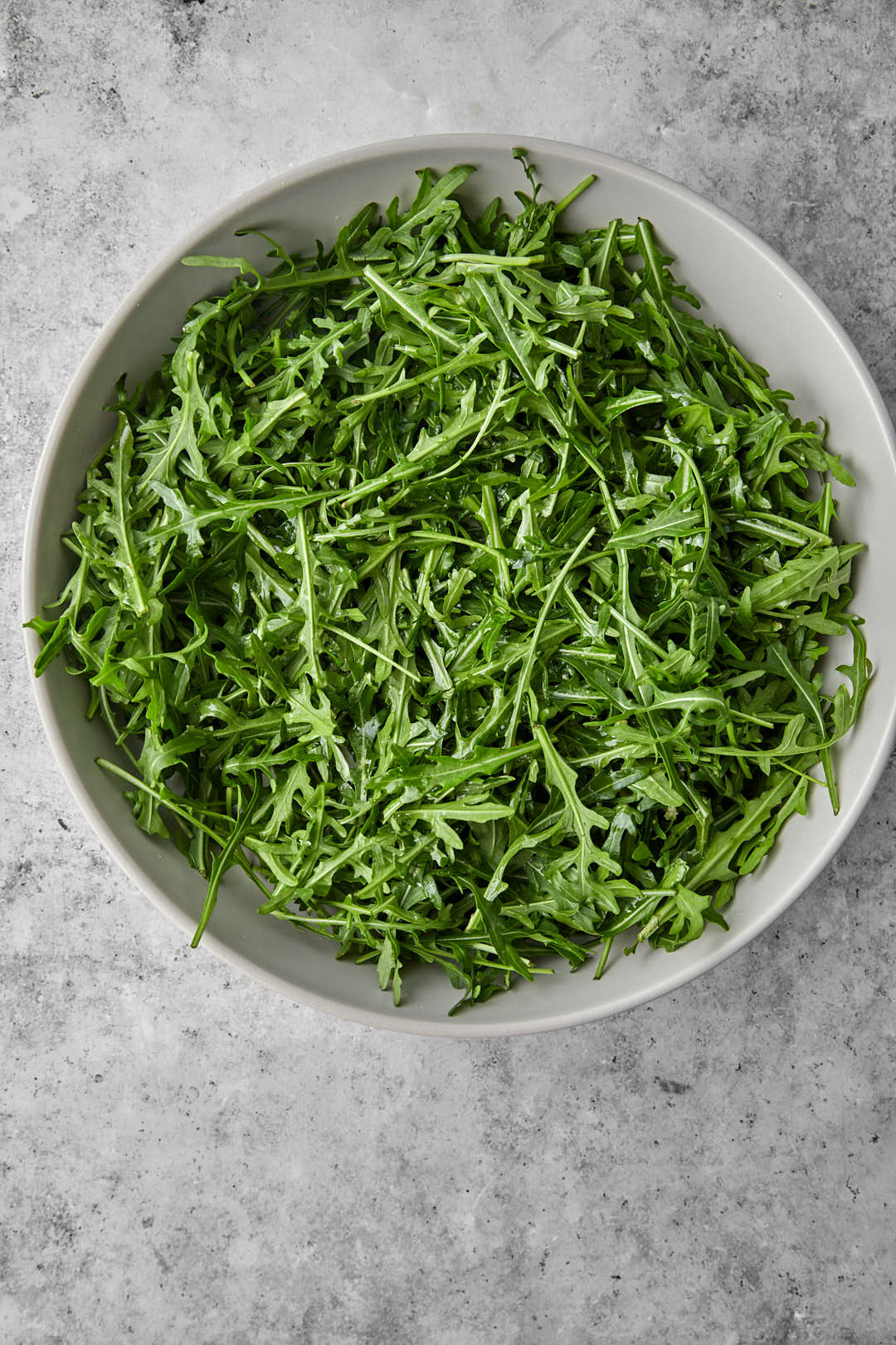 arugula layered in a gray salad dish.