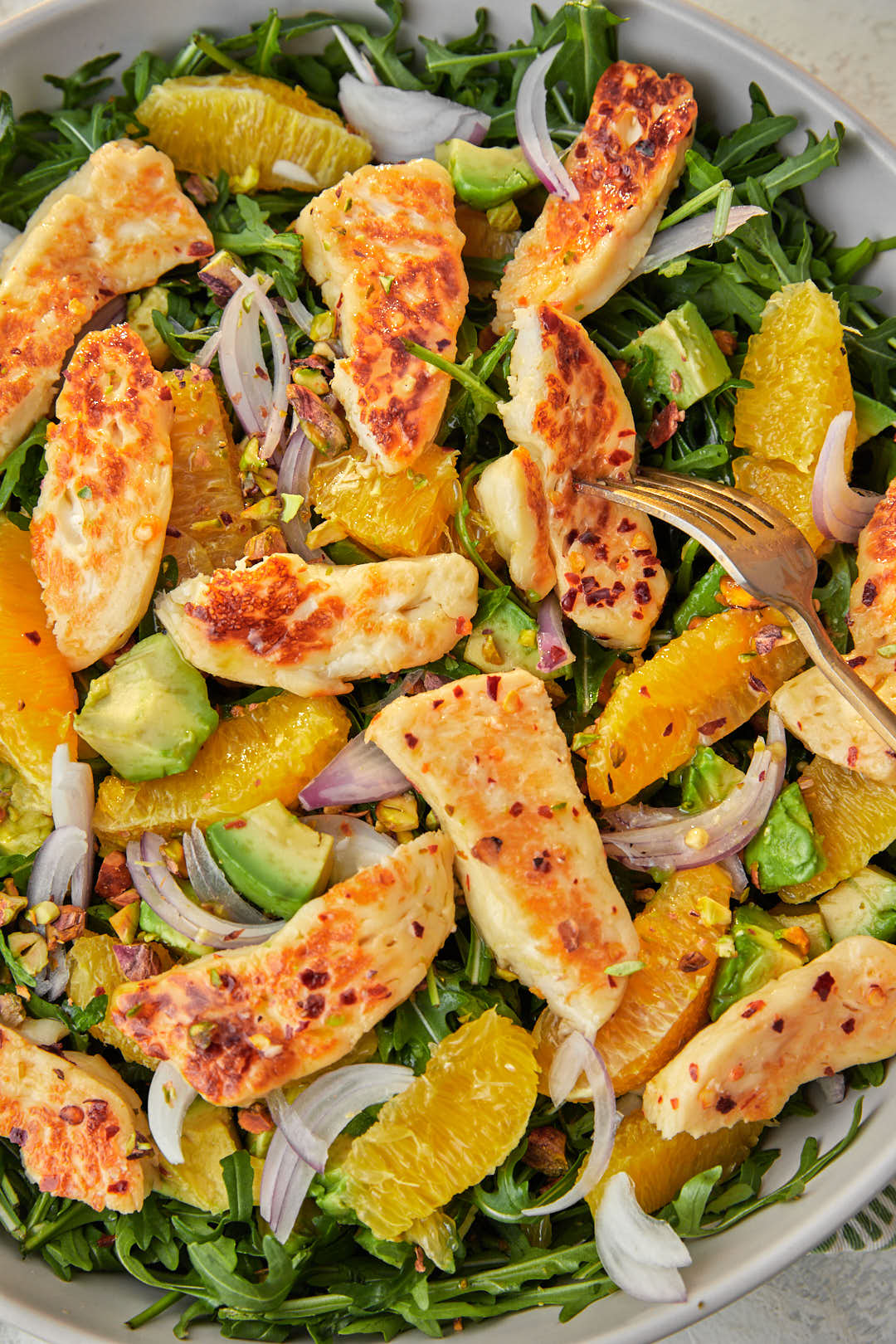 fried halloumi avocado and orange salad in a gray serving bowl.