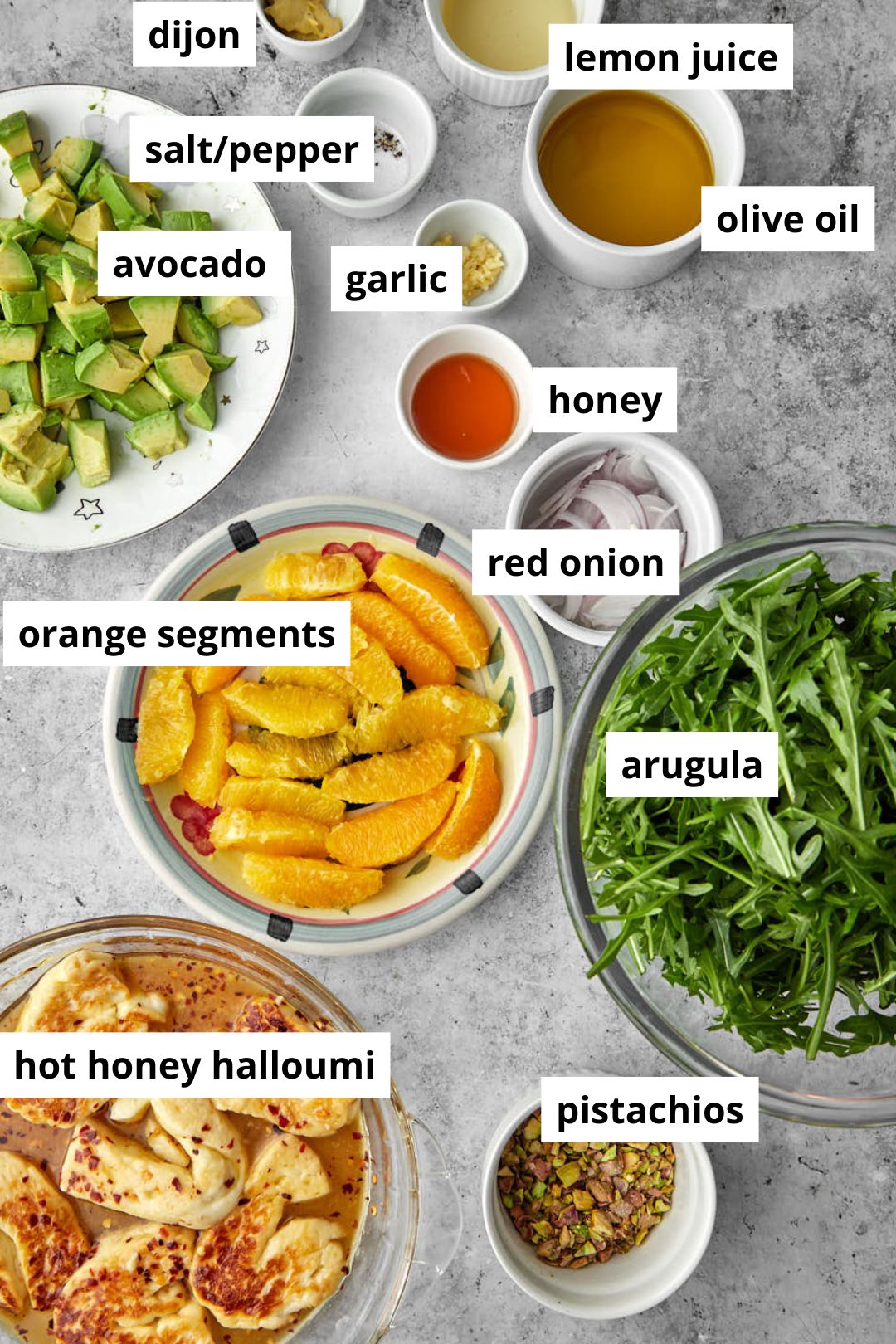 ingredients needed to make fried halloumi salad on a gray background.