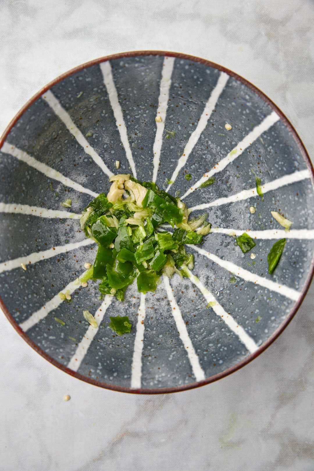 green chili and garlic smashed into a paste in a blue bowl.
