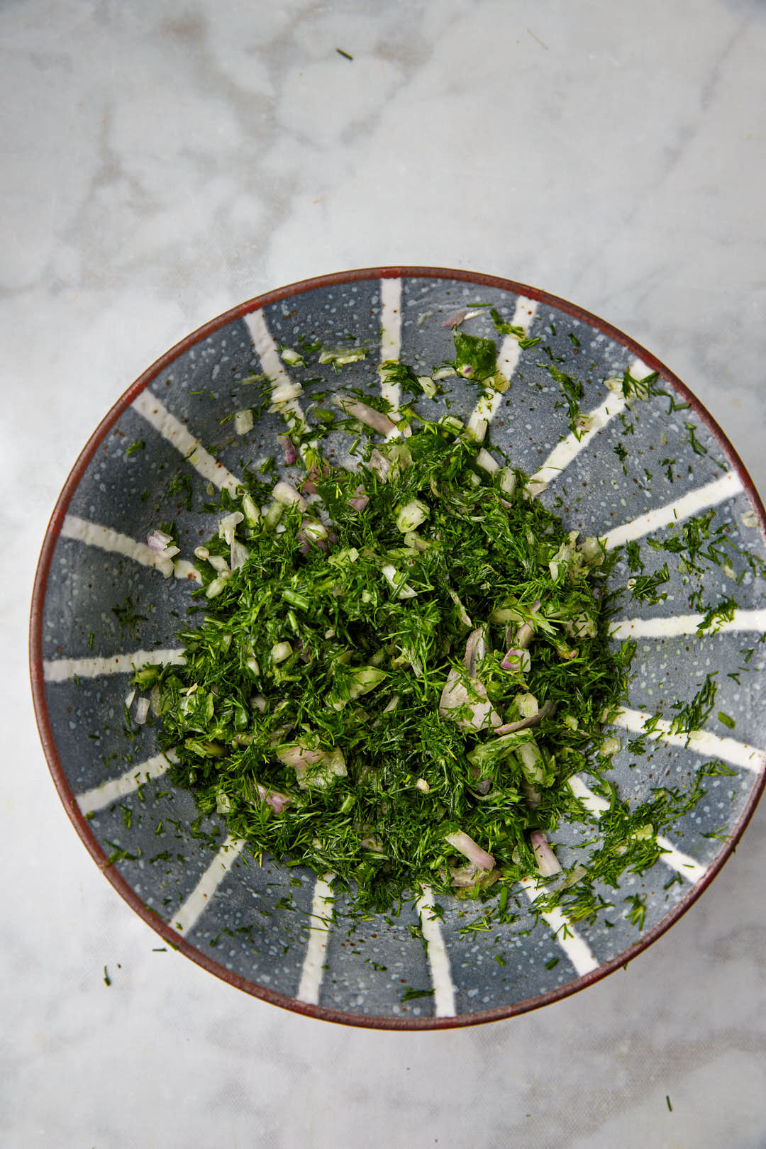 chopped dill in a blue bowl.