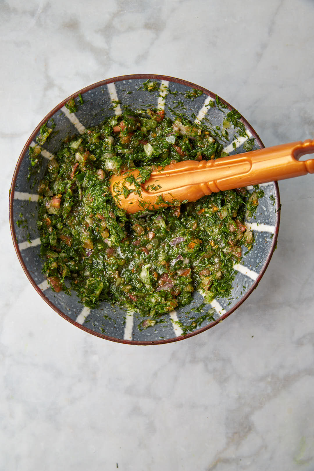 finished gaza salad in a blue bowl with a pestle.