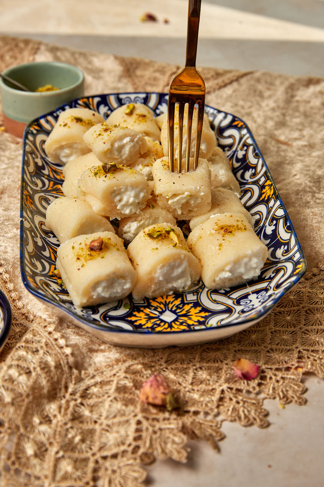 a fork spearing a halawet el jibn roll of a platter.