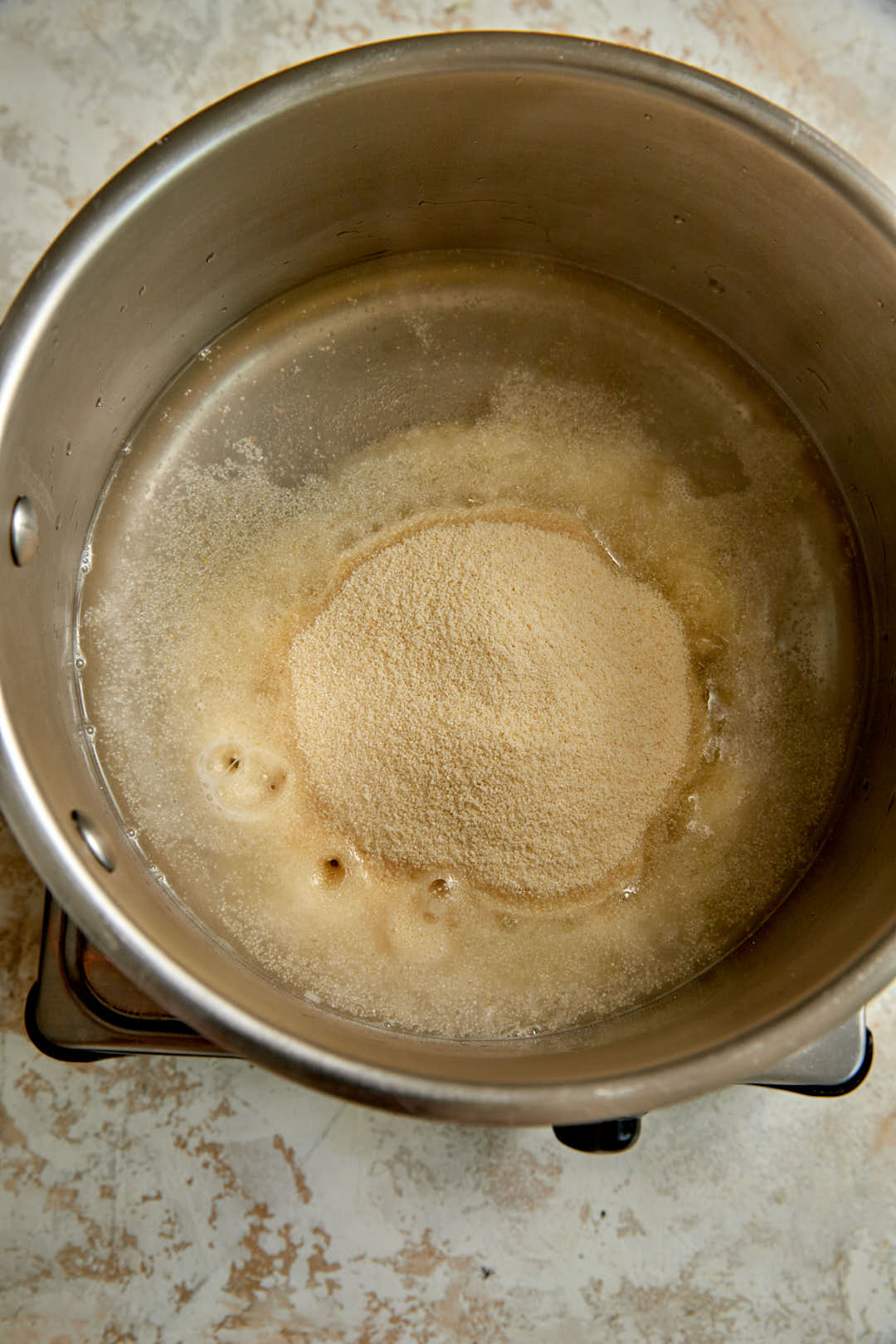 fine semolina added to a sugar water mixture in a saucepan.