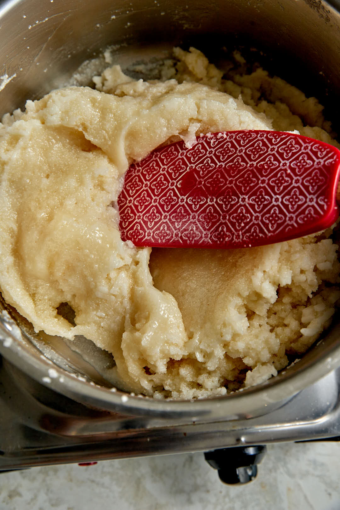 halawet el jibn mixture in a saucepan with a red spatula.