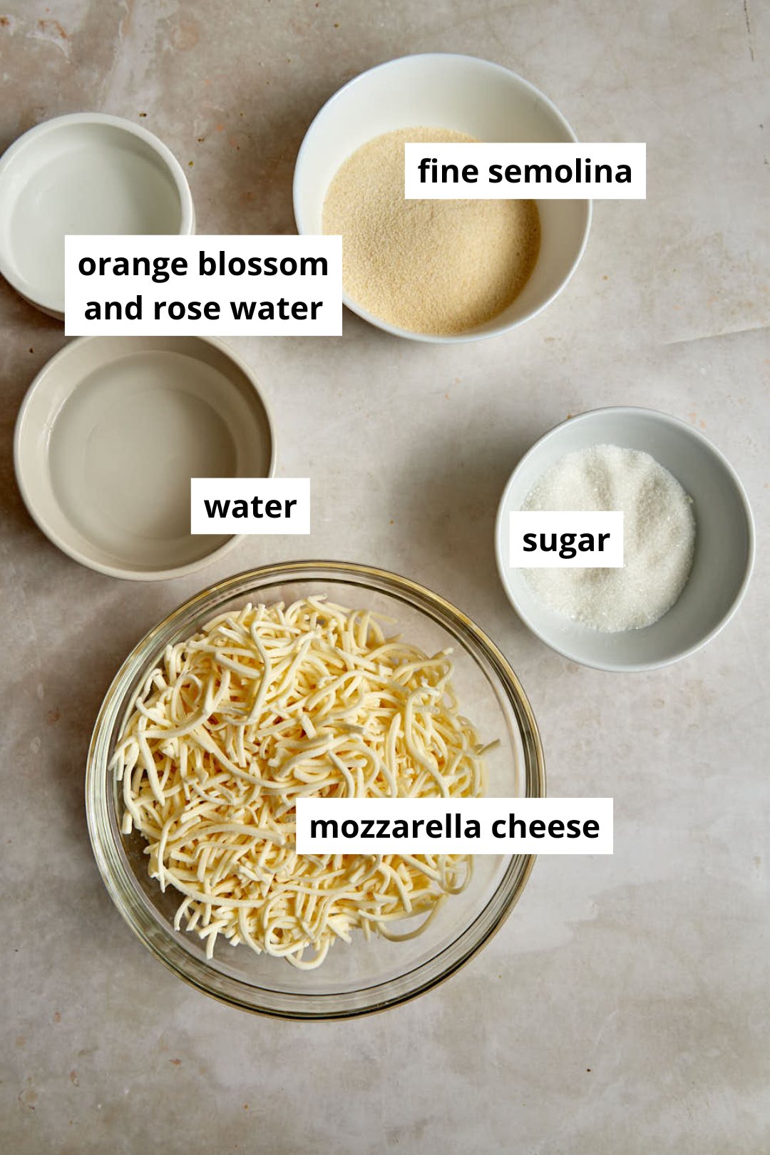 ingredients needed to make halawet el jibn on a marble background.