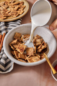 milk being poured into a bowl of healthy homemade cinnamon toast crunch cereal.