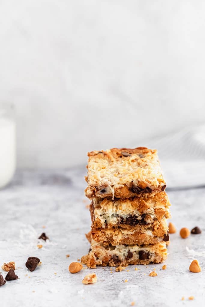 stack of seven layer bars with a glass of milk in teh background