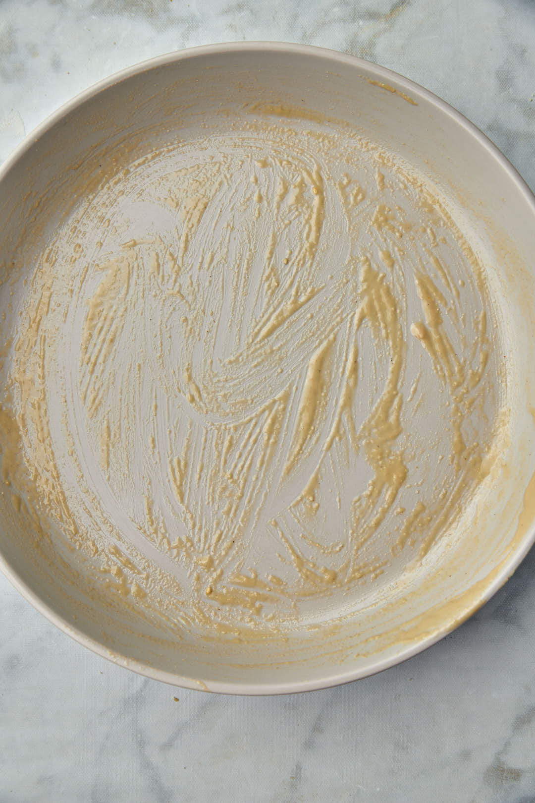 circular baking pan greased with tahini.