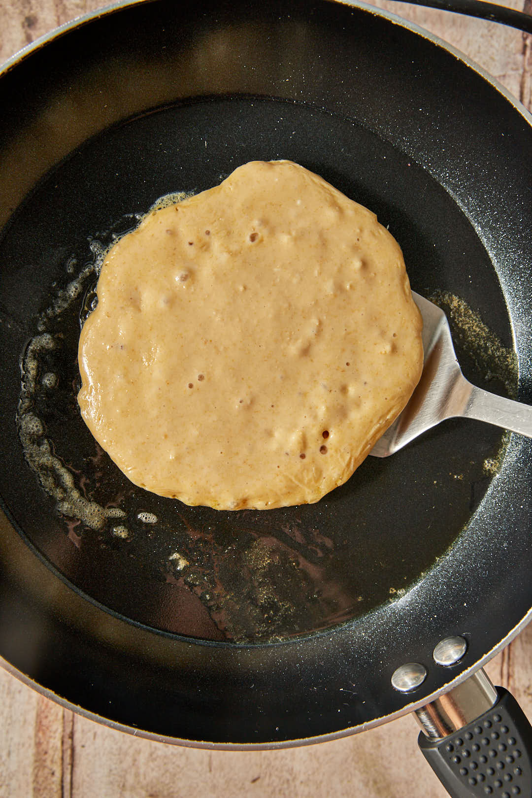 cottage cheese pancake batter being flipped in a skillet.