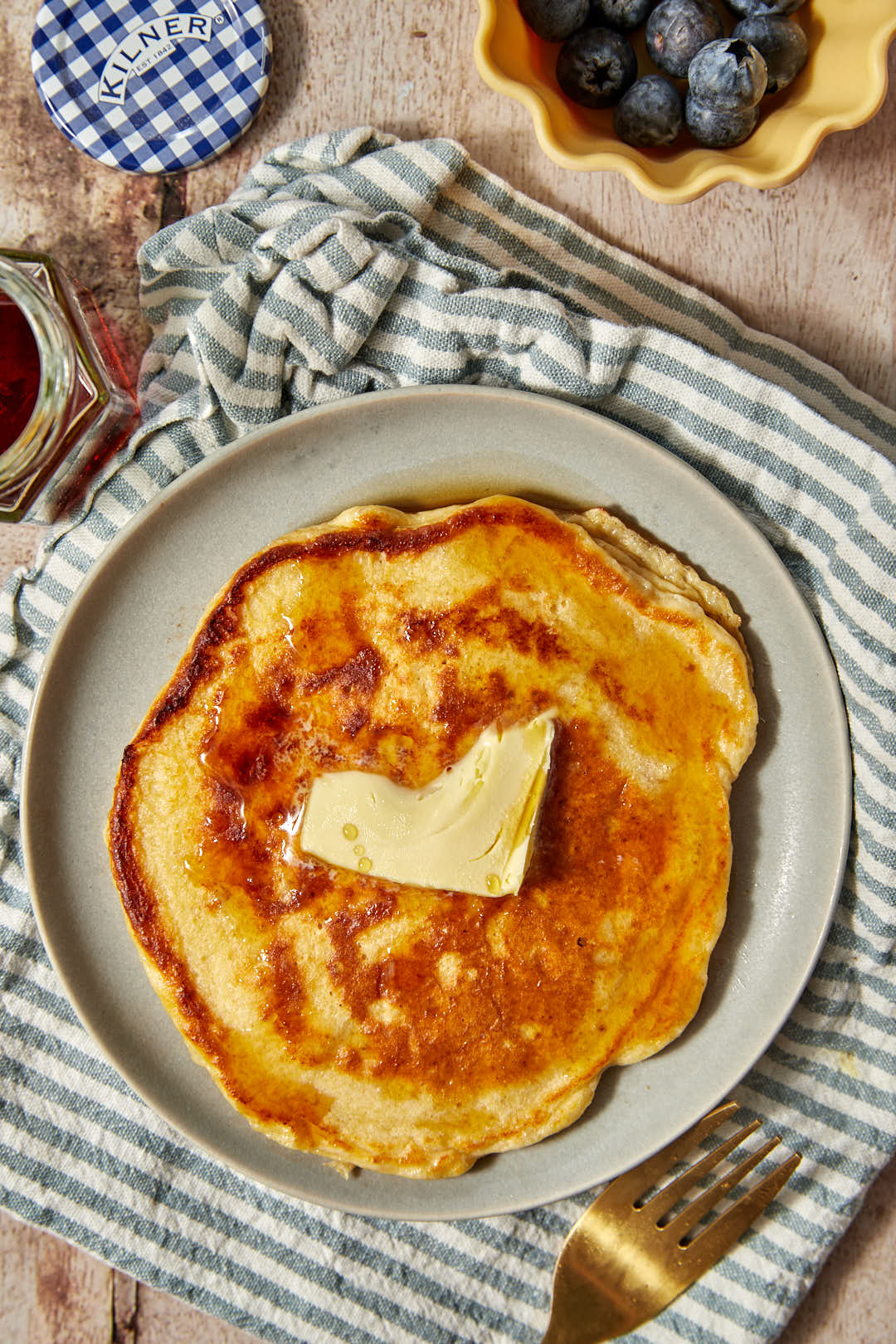 a large high protein pancake on a gray plate with a pat of butter on top.