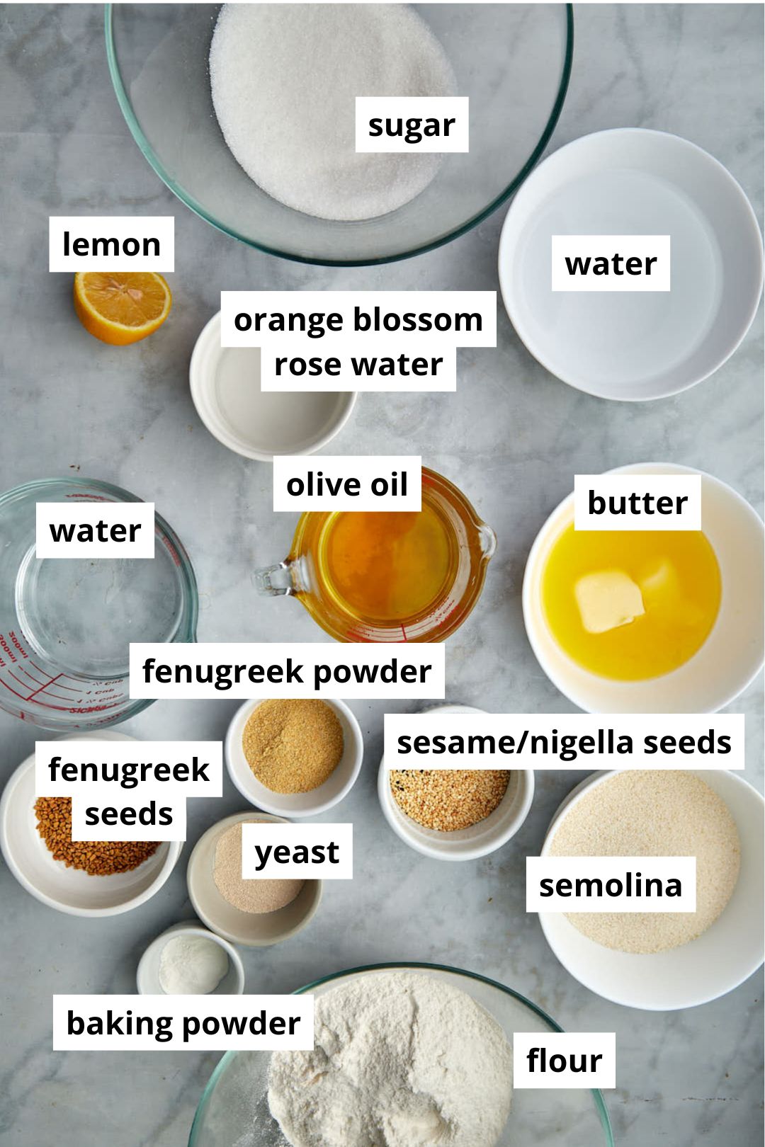 ingredients you need to make hilbeh on a white marble background.