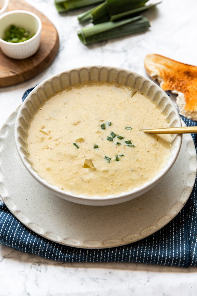 bowl of potato leek soup with bread on the side