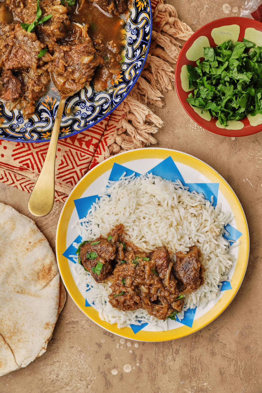egyptian stewed beef on colorful plate with a large plate of beef in the background.