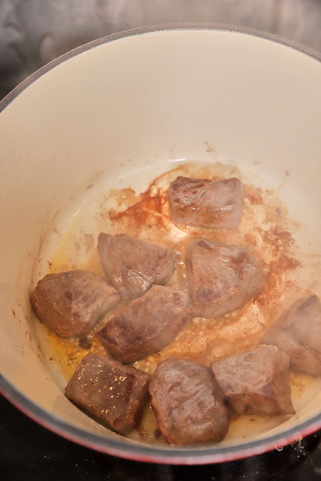 Browned beef cubes in a pan.