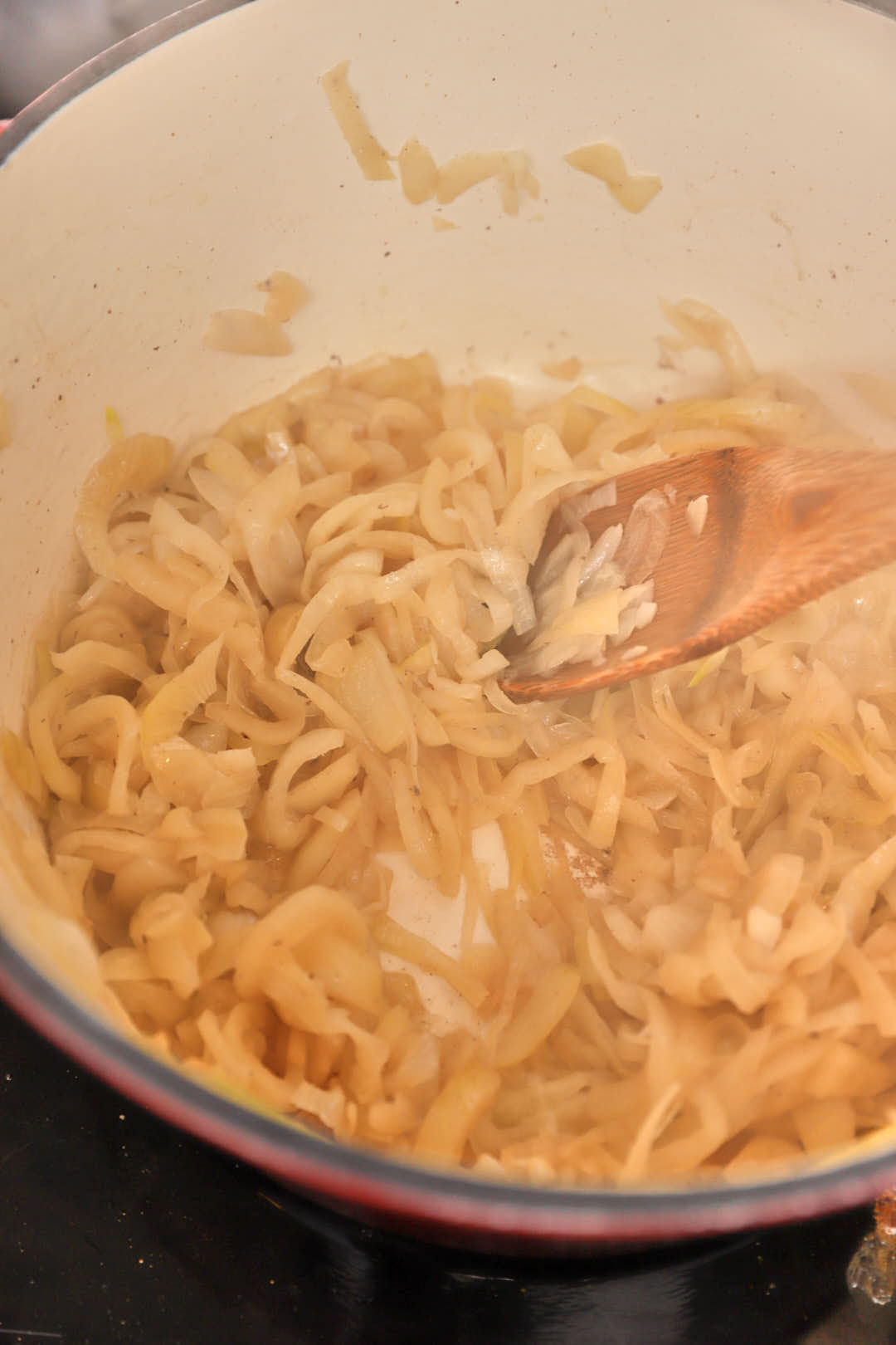 sliced yellow onions softening in a pot.